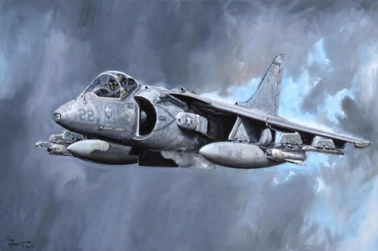 Two-seat US Navy attack aircraft in flight, gray with star insignia, carrying external fuel tanks and ordnance under the wings.