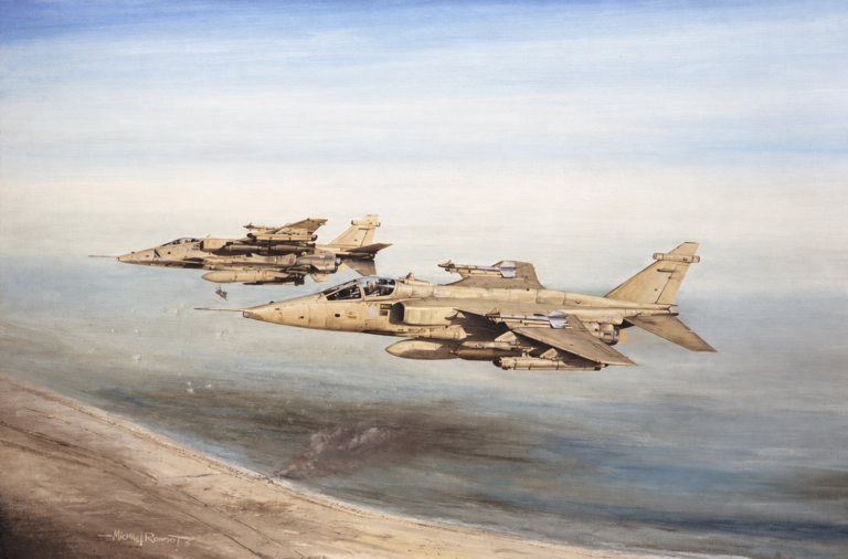 Two beige military fighter jets fly in formation over a coastline and sea, missiles mounted under their wings.