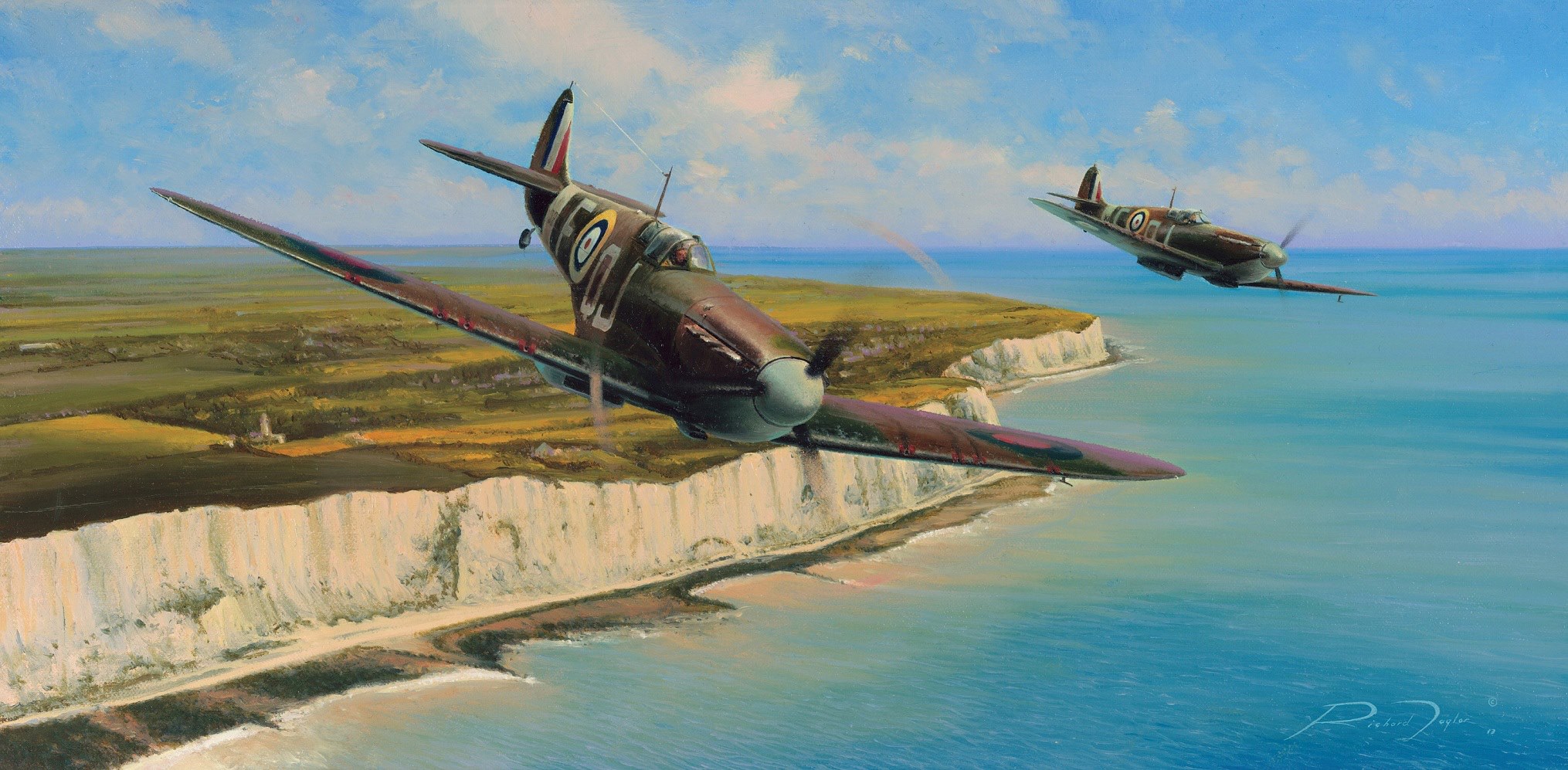 Two Spitfires flying low along a coastline above white cliffs and blue sea.